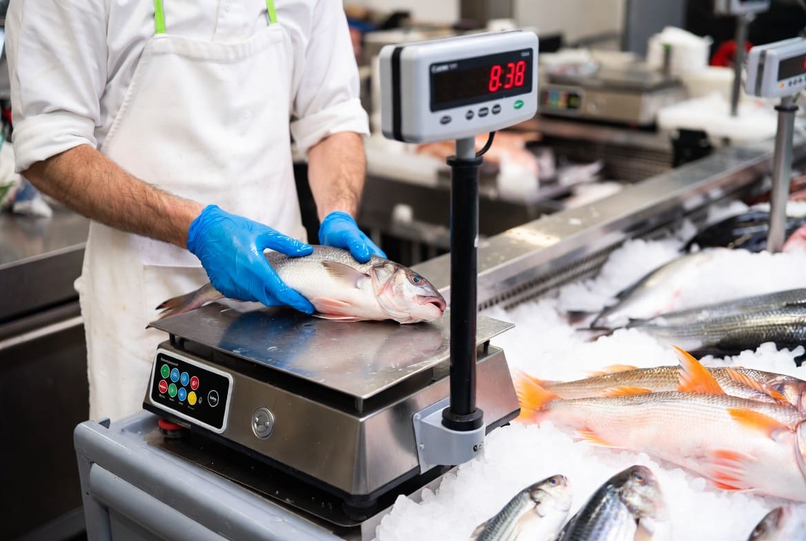 Poissonnerie 974 — pesée du poisson sur balance inox poids-prix à afficheur